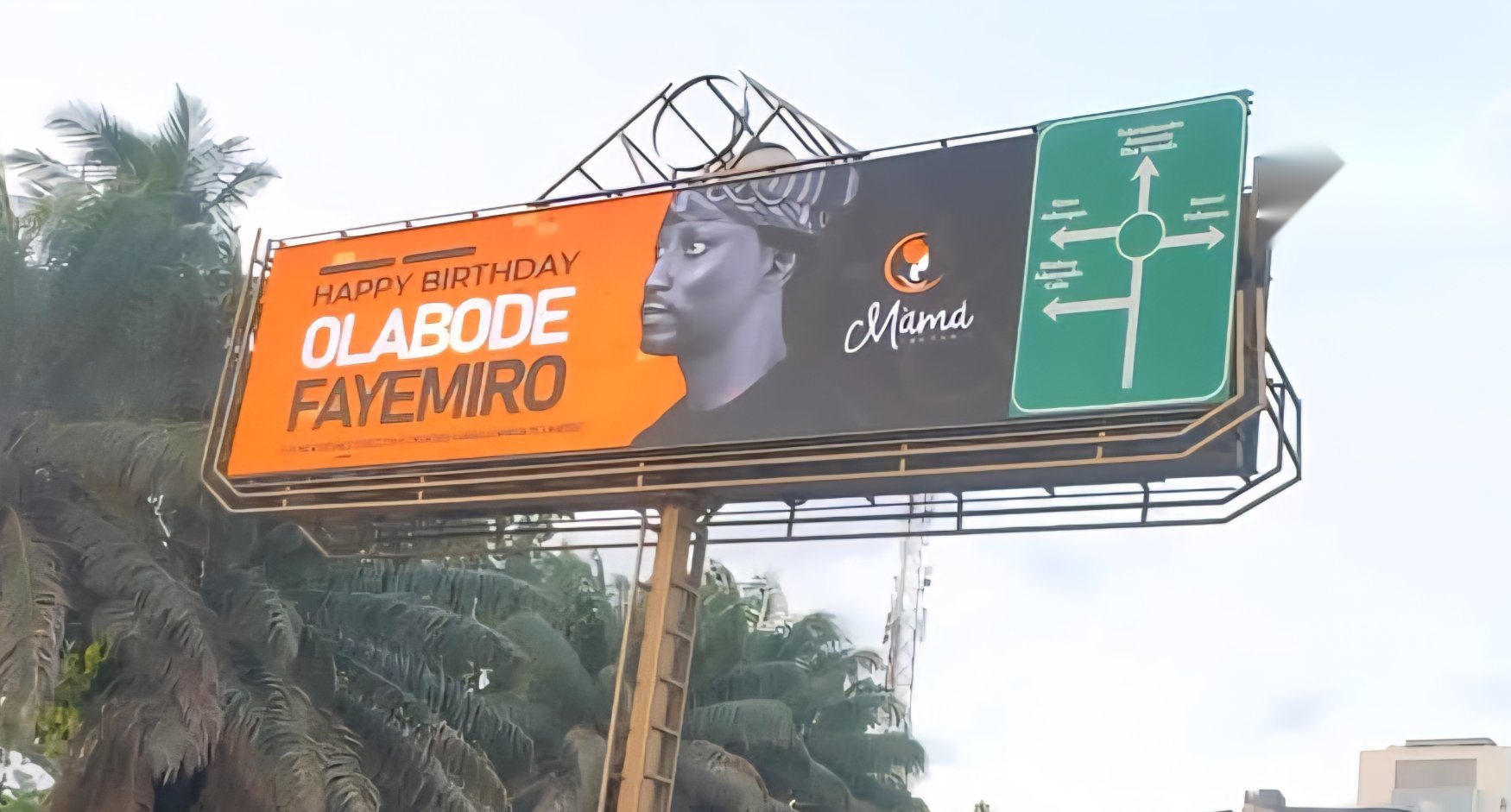 Large-format digital billboard on a palm-lined road
